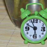 Un bicchiere di acqua con limone e erbe fresche per depurare il fegato al mattino.