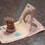 Infermiere al lavoro in ospedale, riflettendo sulle differenze salariali tra settore pubblico e privato.