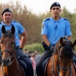 Vigile urbano in uniforme mentre controlla il traffico in una strada di città.